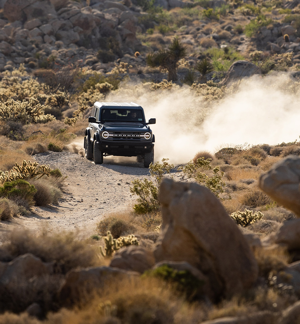 SUV fährt durch staubiges Gelände