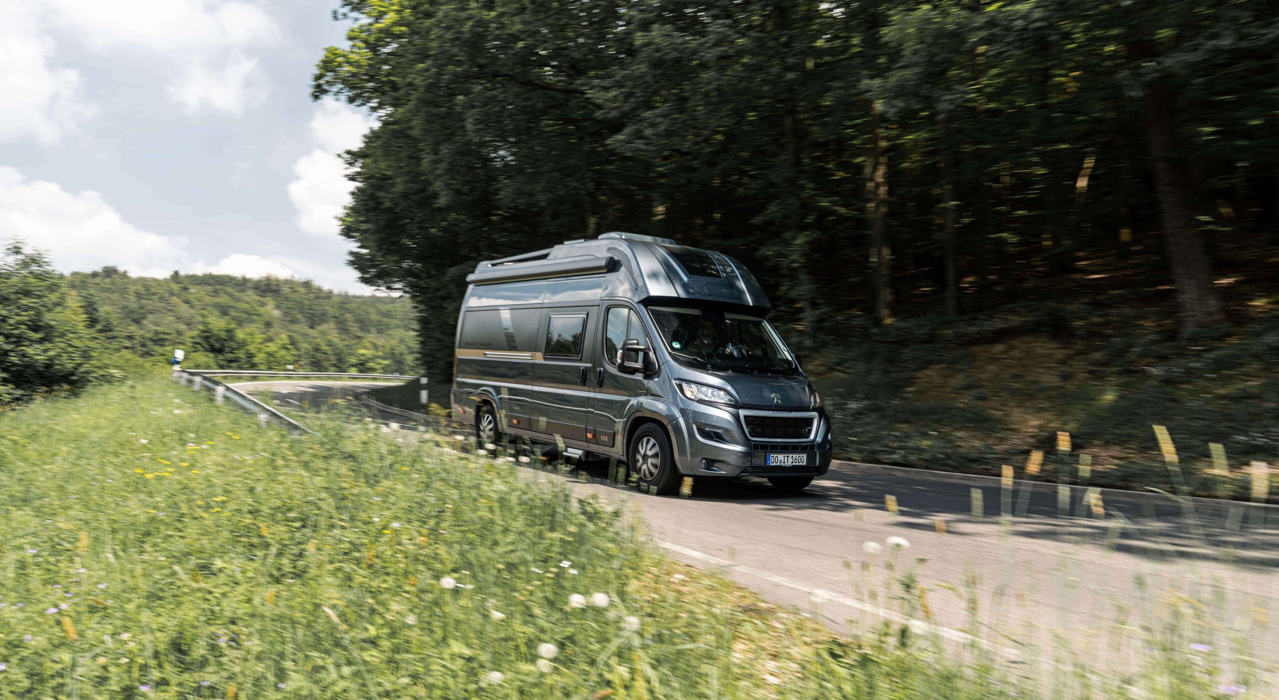 Teilintegrierter Camper mit BILSTEIN Stoßdämpfer fährt über Landstraße