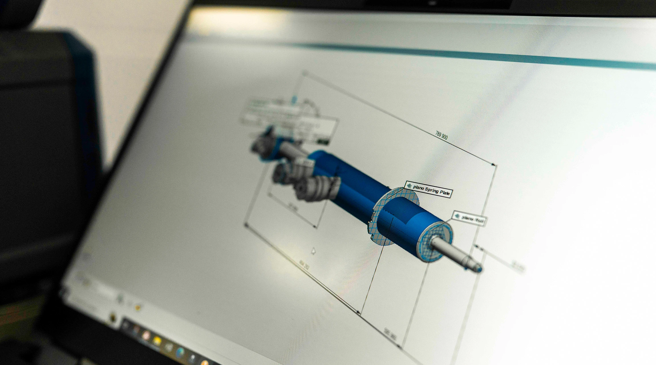A technical drawing of a BILSTEIN shock absorber can be seen on the laptop display.